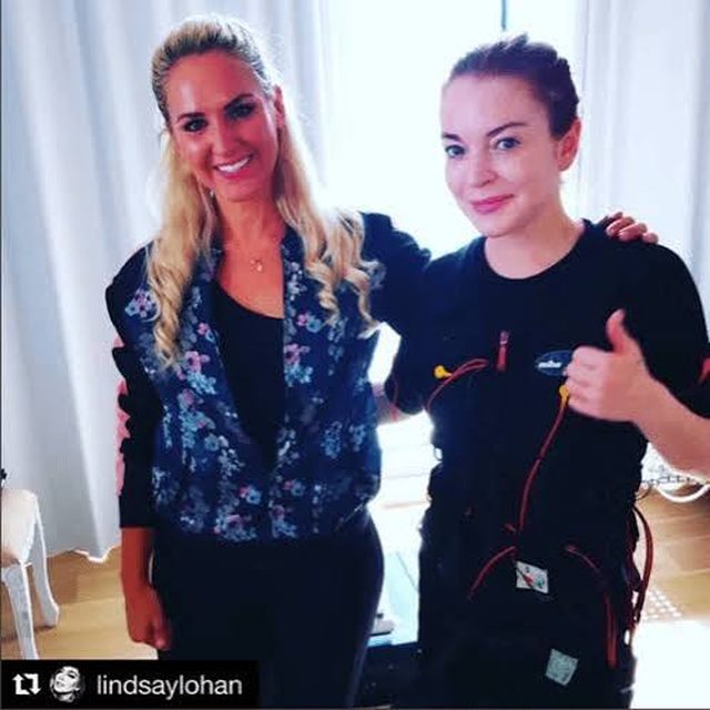 Lindsay Lohan wearing a miha bodytec EMS suit, giving a thumbs up